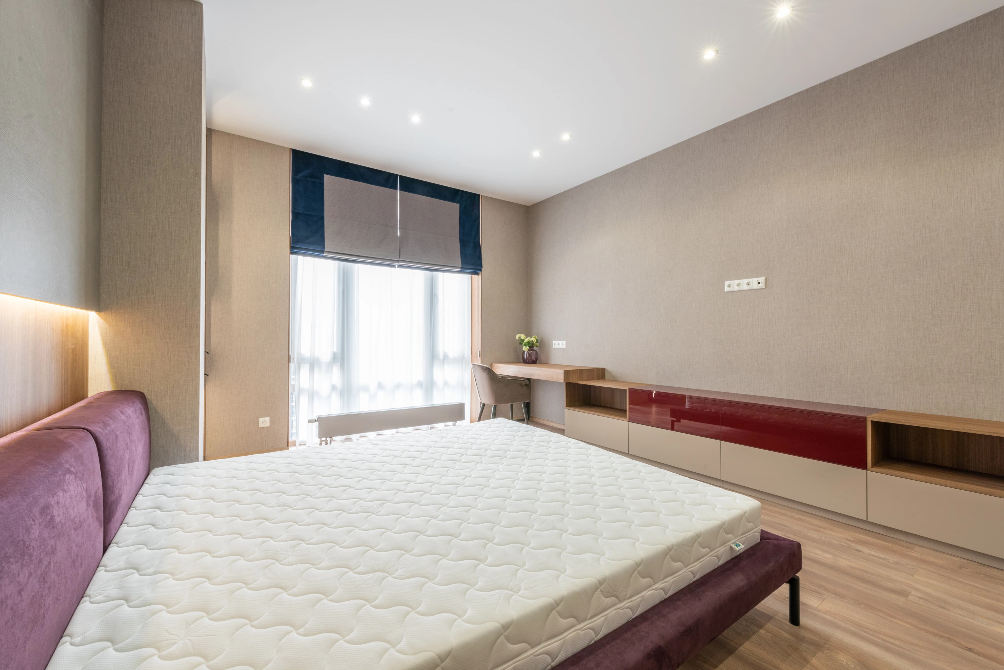 Layered luxury mattress construction in a sunlit bedroom